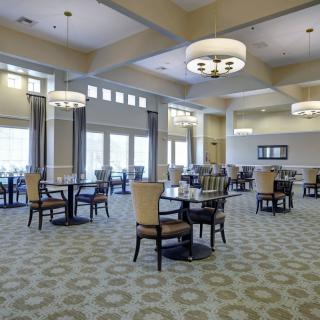 A spacious dining room with elegant lighting and modern furnishings.