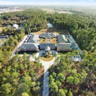 Aerial view of a building complex surrounded by forested area.