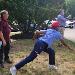 A group of men engaged in an outdoor throwing activity, capturing a dynamic moment.