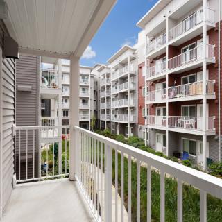 View from a balcony overlooking modern residential apartment buildings.