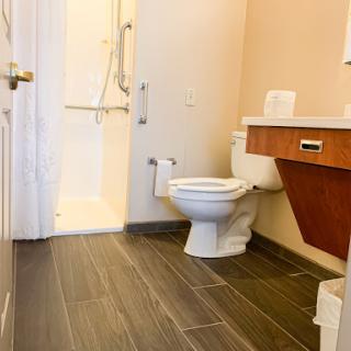 A clean and modern bathroom featuring a shower, toilet, and sleek tile flooring.