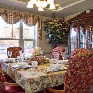 A beautifully set dining room table with ornate chairs and elegant dinnerware.