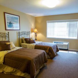 A cozy bedroom with twin beds and natural lighting.