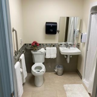 A clean and well-organized bathroom with a toilet, sink, and shower.