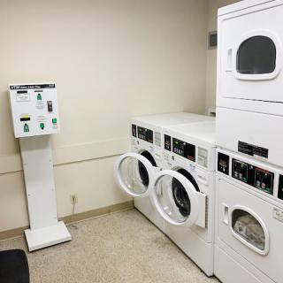 A laundry room with coin-operated washing machines and dryers.