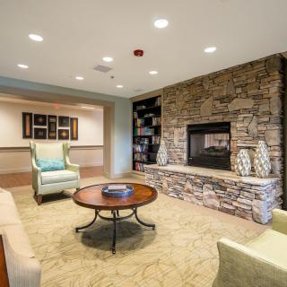 A cozy living room featuring a stone fireplace and comfortable seating arrangements.