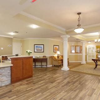 A modern reception area with wood flooring, a comfortable waiting space, and elegant lighting.