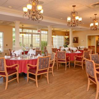 An elegant dining room with neatly arranged tables and chandeliers.