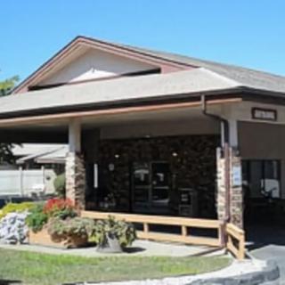 An exterior view of a building entrance with a porch and landscaping.