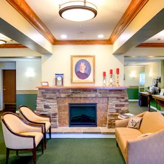 A cozy lobby featuring comfortable seating, a decorative fireplace, and inviting decor.