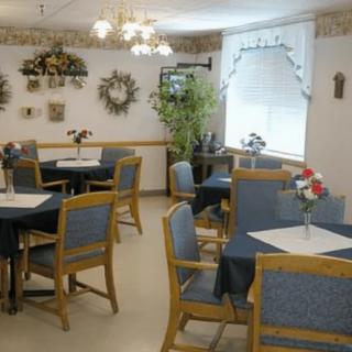 An elegantly decorated dining area with tables and chairs, adorned with flowers and soft lighting.