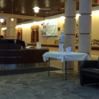 A hotel lobby with a reception desk and a waiting area.