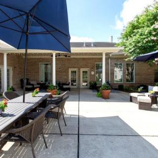 A spacious outdoor patio with seating and umbrellas on a sunny day.