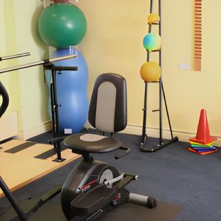 A compact home gym setup with a stationary bike and exercise balls.
