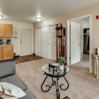 A cozy living space in an apartment with a sofa, coffee table, and open kitchen area.
