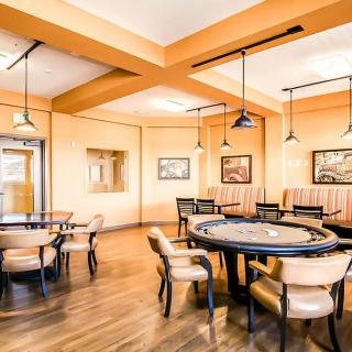 A cozy lounge area with comfortable seating, modern lighting, and art on the walls.