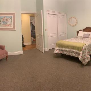 A cozy bedroom with a neatly made bed and comfortable seating.