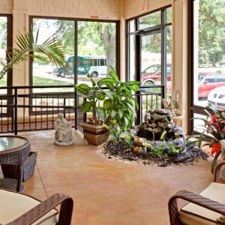 A serene and inviting lobby with lush greenery and a calming water feature.
