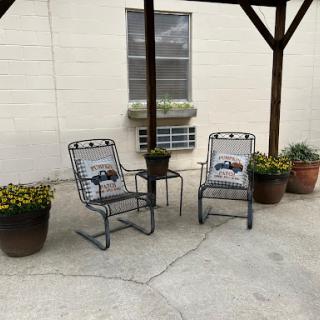 A peaceful outdoor seating area with comfortable chairs and potted plants.