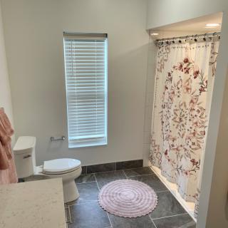 A modern bathroom with a floral shower curtain and minimalistic design.