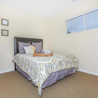 A cozy bedroom with a neatly made bed and simple decor.