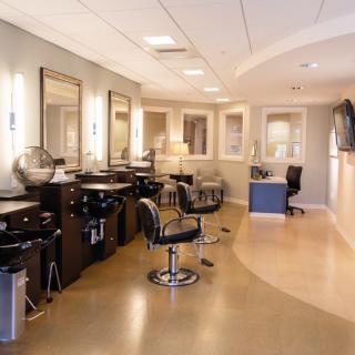 A modern hair salon interior with stylish chairs and mirrors.