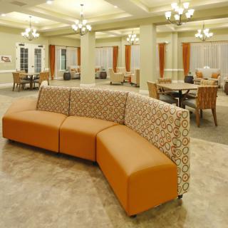 A modern lobby featuring a stylish orange and patterned sofa arrangement.