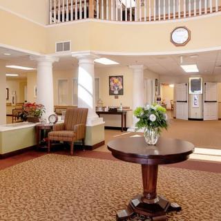 A warmly decorated lobby with comfortable seating and a central table adorned with flowers.