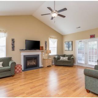 A spacious living room with a fireplace, television, and comfortable seating.