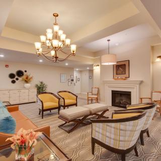 A cozy living room featuring elegant furniture and a grand chandelier.