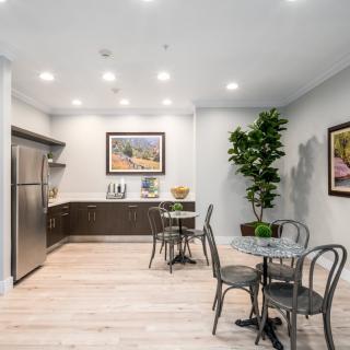 A modern kitchen and dining area featuring minimalistic design, stainless steel appliances, and elegant decor.
