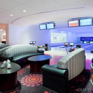 Modern bowling alley with comfortable seating and digital screens.
