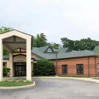 A building with a covered entrance and a circular driveway.