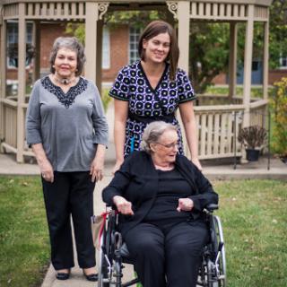 A heartfelt moment captured outdoors, showcasing the bond among three women.