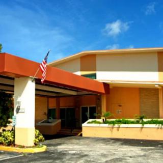 A sunny view of a hotel entrance with an American flag.
