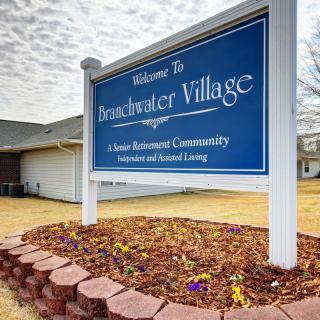 A sign for Breakwater Village, a senior retirement community, with landscaped surroundings.