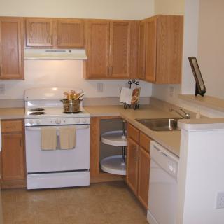 A kitchen with wooden cabinets, a stove, and various appliances.