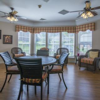 A cozy living room with multiple seating arrangements, large windows, and abundant natural light.