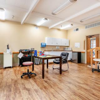 A spacious office workspace featuring a desk, chairs, and ample lighting.