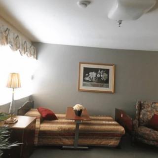 A cozy living room with a couch, artwork on the wall, and a lamp for lighting.