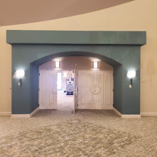 An elegant entrance featuring a blue archway and double doors, complemented by stylish wall sconces.