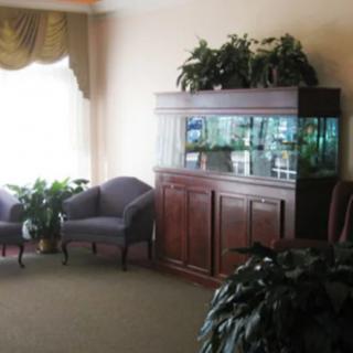 A waiting room with comfortable seating, an aquarium, and decorative plants.