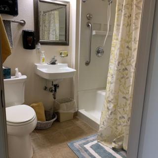 A neatly organized bathroom with a shower, toilet, and sink.