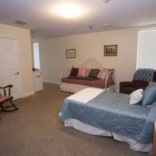 A cozy bedroom with a bed, sofa, and various furniture pieces.