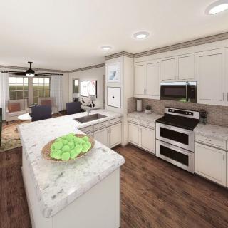 A modern kitchen with white cabinets, stainless steel appliances, and an island in an open-concept layout.