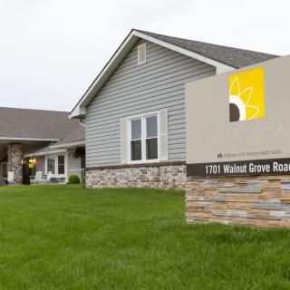 A residential house with a sign in front displaying an address.