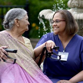 A joyful moment between a caregiver and an elderly woman, highlighting the warmth of companionship in healthcare.