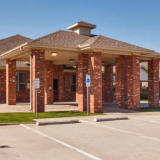 A brick building with a drive-through and parking area.