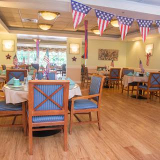 A cozy restaurant interior adorned with American flags, featuring wooden tables and comfortable seating.