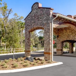 A stone building with a covered entrance and surrounding landscaping.